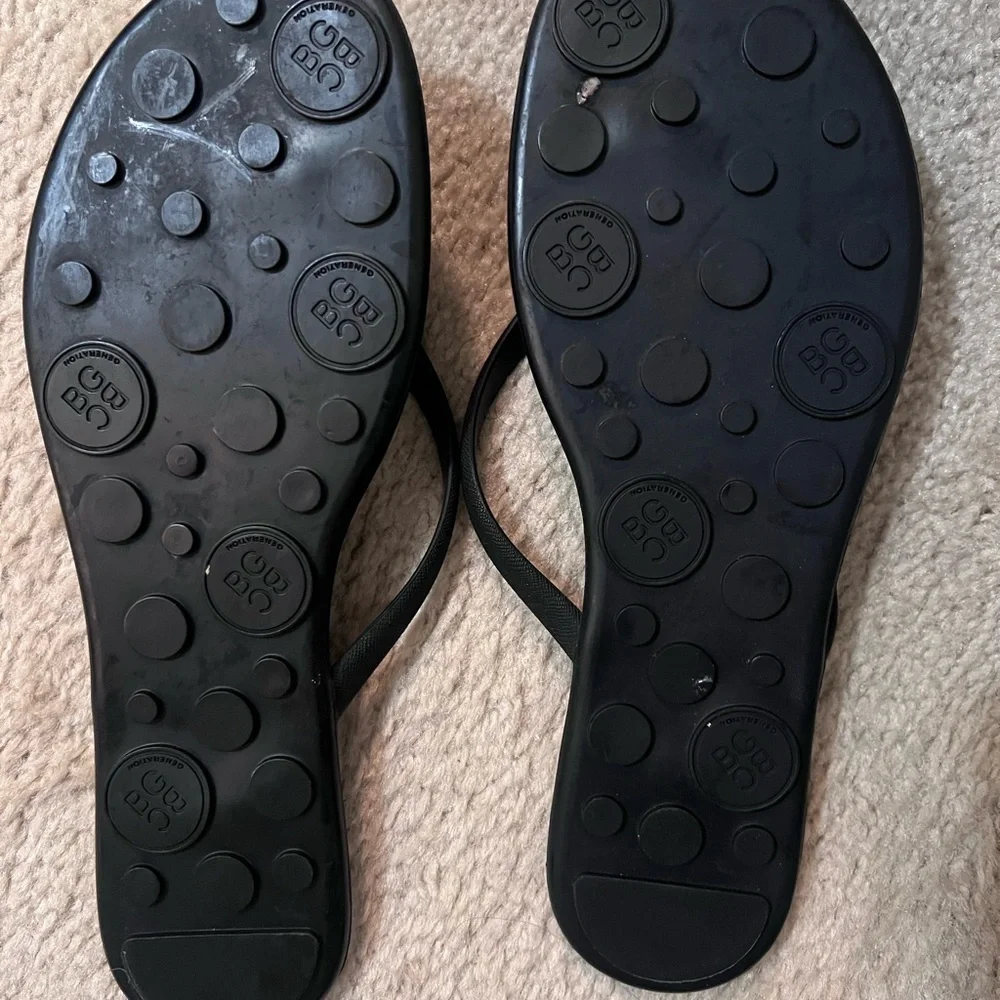 BCBGeneration Black Thong Sandals with Gold Logo Accent